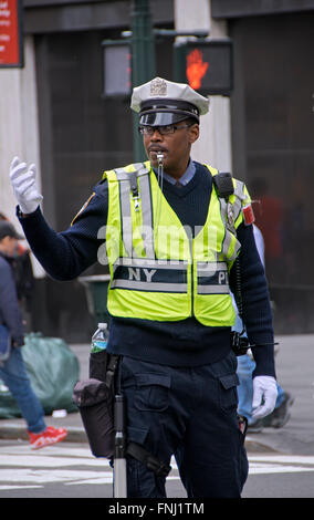 A male New York City Traffic Enforcement Officer directing cars at East 34th Street and Park Avenue in New York City. Stock Photo