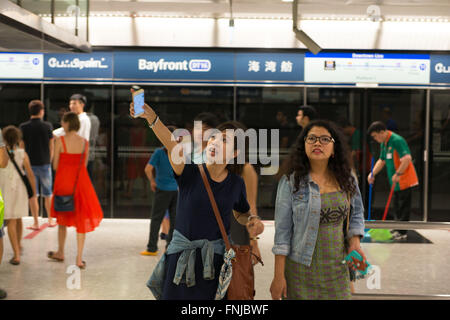 Two women in Singapore Bayfront Subway station pointing to the map Stock Photo
