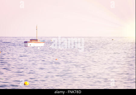 Lonely anchored boat in the morning sea Stock Photo