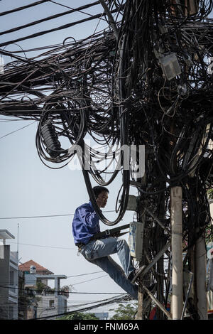 technician with mobile phone repairing fixing messy cables  - communication / network concept: Stock Photo