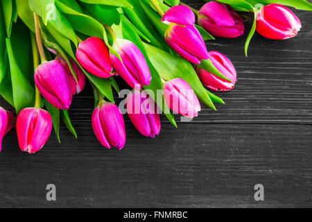 Bright spring pink tulips flowers bouquet over wooden background Stock Photo