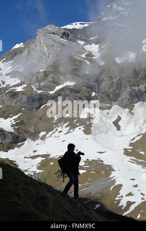 A man is taking a photographs on the steep slope in the mountain amphitheater deTroumouse. Stock Photo
