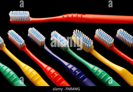 Multi Colored toothbrushes on black background. Stock Photo