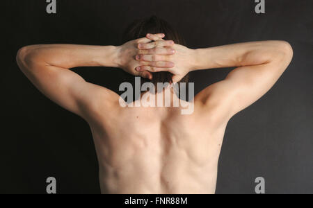 Teenage boy flexes his muscles. Stock Photo