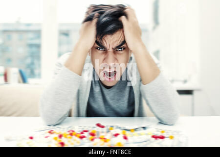 Crazy man sitting at the table and screaming Stock Photo