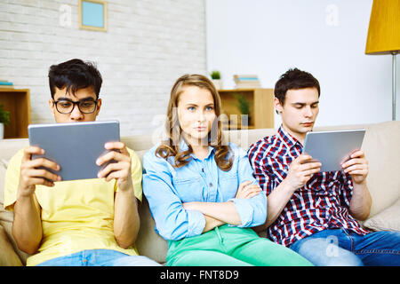 Two men using touchpad with woman sitting between them Stock Photo
