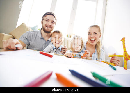 Portrait of happy young family sitting on sofa Stock Photo