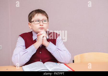 boy with glasses sitting in thought Stock Photo