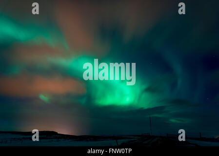 The Northern Lights out shining the orange light pollution near Stykkisholmur in Iceland Stock Photo