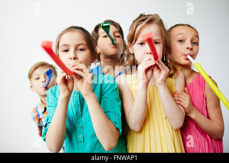 Portrait of children with party horns Stock Photo