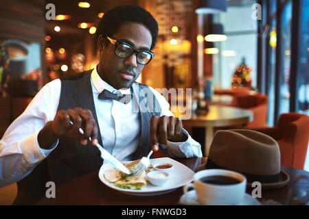 Elegant young man having lunch in cafe Stock Photo