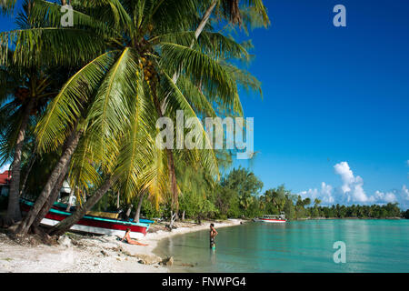 A couple relaxes in the beach of Rangiroa, Tuamotu Islands, French Polynesia, South Pacific. Stock Photo