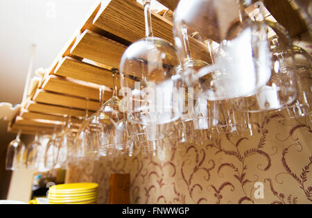 wine glasses hanging upside down on bar holder Stock Photo