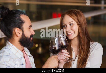 couple drinking red wine and clinking glasses Stock Photo