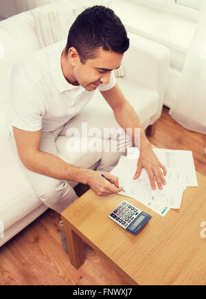 man with papers and calculator at home Stock Photo