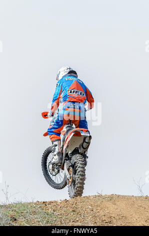 Spain cross country championship. Back view of motorcyclist is jumping with his motocross motorbike. Stock Photo
