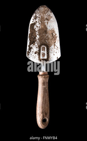Rusty and dirty Garden Trowel with a Wood Handle isolated on a Black background Stock Photo