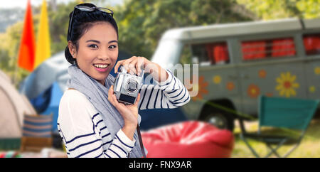 Composite image of smiling asian woman taking photograph with camera Stock Photo