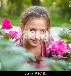 portrait of a girl in a rose bush in the park Stock Photo