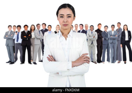 Composite image of serious businesswoman with crossed arms Stock Photo