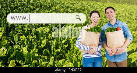 Composite image of couple holding grocery bags Stock Photo