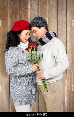 Composite image of older asian man giving his wife flowers Stock Photo