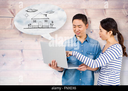 Composite image of couple using laptop Stock Photo