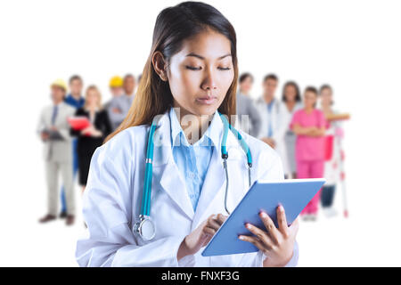 Composite image of asian doctor using tablet Stock Photo