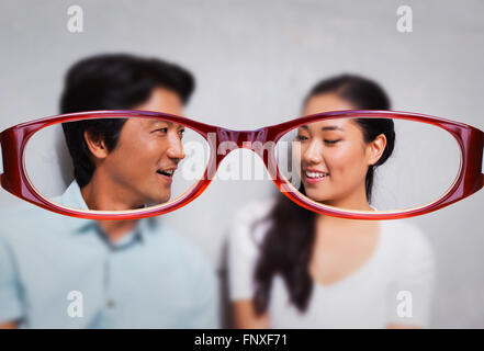 Composite image of happy couple sitting on floor using tablet surrounded by boxes Stock Photo