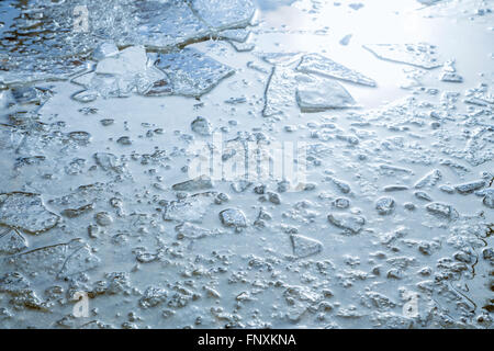 Puddles and chopped ice on the sidewalk in the spring. Stock Photo