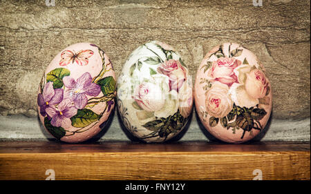 Three Easter eggs stacked on the wooden base. Easter holiday. Symbol of springtime. Stock Photo