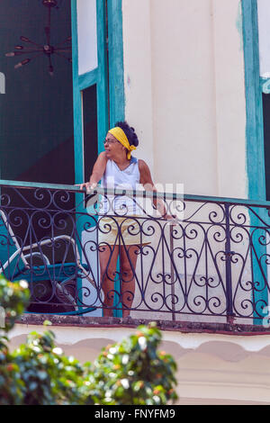 HAVANA, CUBA - APRIL 1, 2012: Hispanic women looking from balcony of old house  Editorial use only. Stock Photo