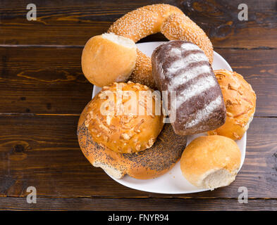 Assorted bread rolls and a bagel on a plate with seed bread, rusty white bread and wholegrain, viewed from above Stock Photo