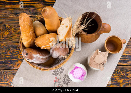 Healthy breakfast of assorted freshly baked crusty gourmet breads and milk served in bottles, overhead view Stock Photo