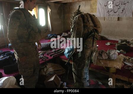 U.S. Army soldiers search through a weapons and ammunition cache found while searching a hotel during Operation Mountain Fire July 12, 2009 in Barge Matal, Nuristan Province, Afghanistan. Stock Photo