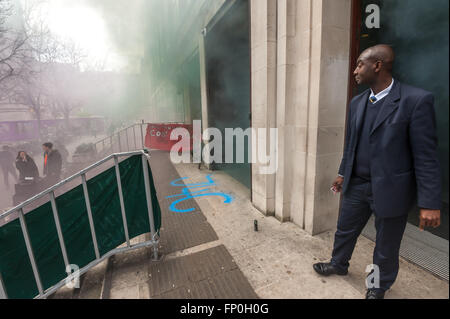 London, UK. 16th March, 2016. Students, cleaners and staff celebrate at the School of Oriental and African Studies (SOAS) as talks continue which seem likely to end the 10 year battle to bring cleaning staff 'in-house' rather than employed under poor conditions by contracting companies. As the smoke clears after the flares let off in celebration the lettwers J4C can be seen in front of the entrance doors. Peter Marshall/Alamy Live News Stock Photo