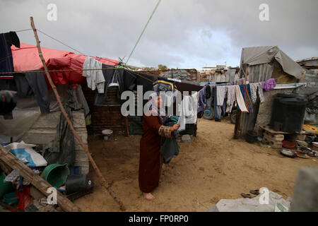 (160317) -- GAZA, March 17, 2016 (Xinhua) -- Palestinian Jihan Moussa Abu Mohsen, 48, hangs clothes to dry outside her house in the southern Gaza Strip city of Khan Yunis, on March 17, 2016. Jihan, who works from the morning hours till late the day, sells a cart of bricks to stone manufacturers for 4 US dollars per day. Her work is the main source of income for her family which consists of her husband and four children. Jihan and her son Ahmad get up early every morning to collect bricks and stones from anywhere they find them, whether in landfills, streets or roadsides. (Xinhua/Khaled Omar) Stock Photo