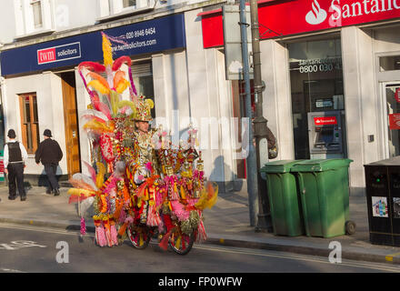 Westminster London,UK. 17th March 2016. A golden man rides a fantasy cycle  through Wimbledon town cycle Credit:  amer ghazzal/Alamy Live News Stock Photo