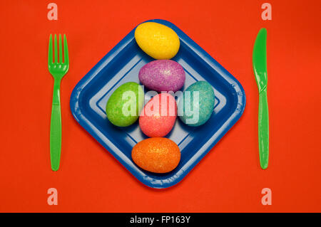 Blue plate on red with fork knife spoon Stock Photo