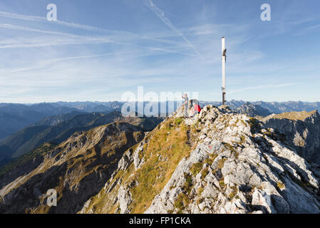 Hikers on the summit of Mount Hochplatte watching the panorama of Ammergau Alps and Tirol on a sunny autumn morning Stock Photo