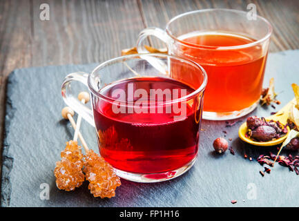 Red berries tea in transparent cups with brown sugar rock candy and dried flowers and fruits Stock Photo