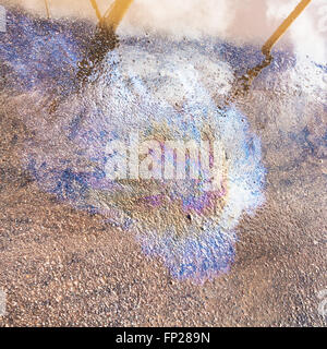rainbow stain of motor oil on wet asphalt pavement in city Stock Photo