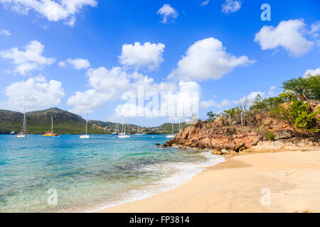 Sandy beach and shoreline at Pigeon Point on English Harbour with moored sailing boats, south Antigua, Antigua and Barbuda Stock Photo