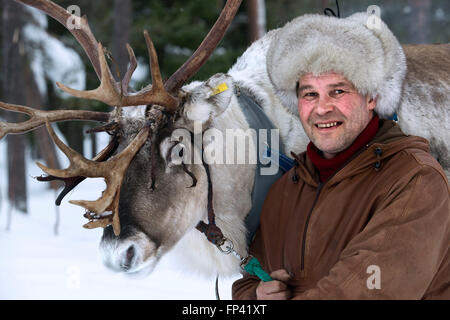 Portrait of a shepherd with his reindeer. Reindeer farm in Salla, Lapland Finland. The reindeer is an icon of Finnish Lapland, a Stock Photo
