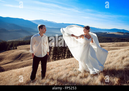 Bride and groom dancing on the mountain. Honeymoon in Alps Stock Photo