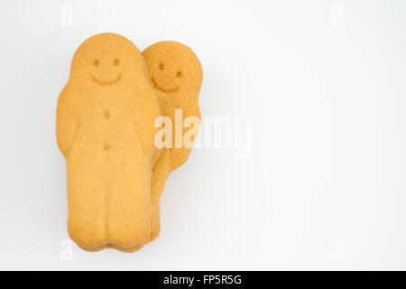A happy gingerbread man looking out from behind others on an isolated white background. Stock Photo