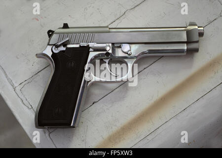 Semi-automatic handgun on Grey wooden background. Stock Photo
