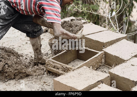 Boy making traditional adobe mud bricks to build his own house in Paru Paru Community Village, Pisaq District, Cusco Region, Peru. Stock Photo