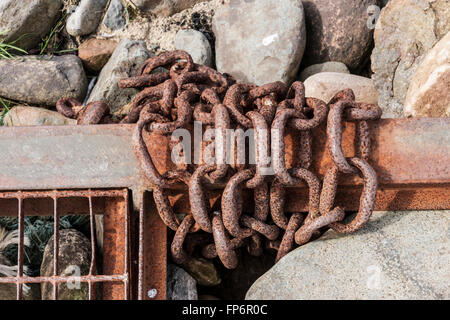 Rusty chain on a stony beach Stock Photo