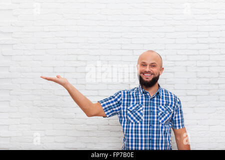 Casual Bearded Man Smiling Open Palm Hand Gesture To Copy Space Stock Photo